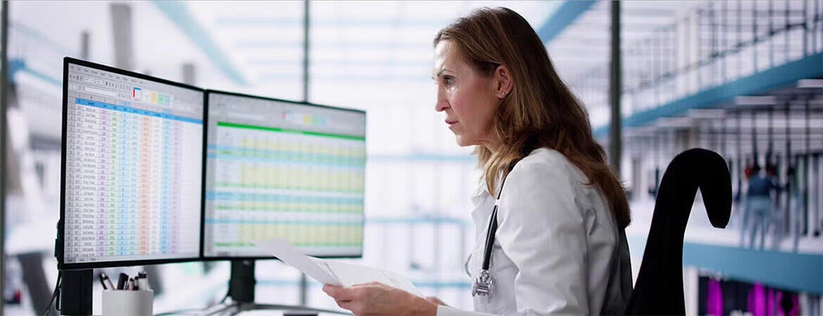 Auditor in front of computer screens