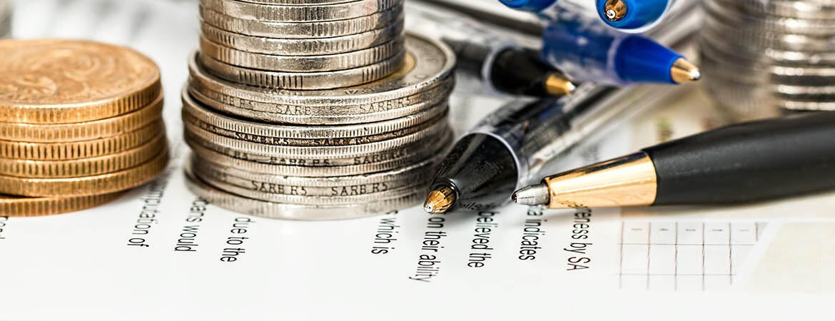 Coins and pencils on tax preparation papers