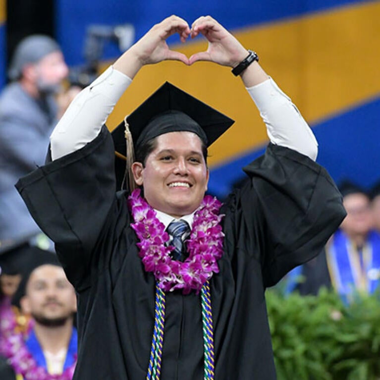 UCR Business student walking at the 2024 Commencement Ceremony