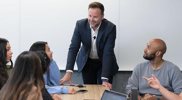 Kyle Ingram and undergraduate business students in a classroom