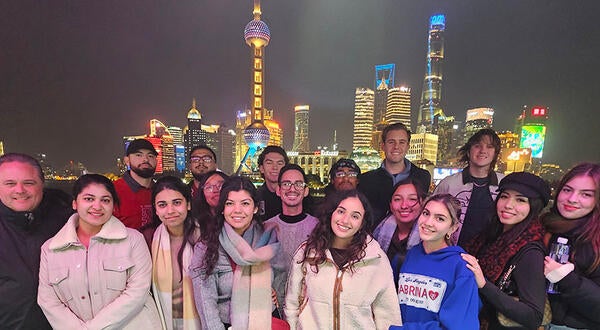 UCR School of Business students standing in front of the Huangpu river, with the city of Shanghai behind them.