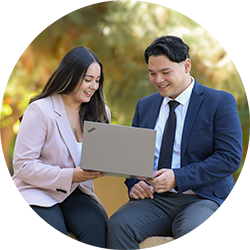 2 Business School students looking at a laptop