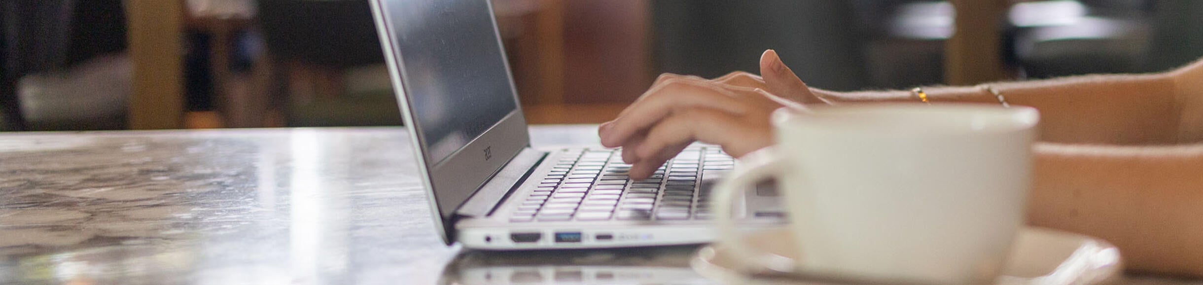 Student working on a laptop in a coffee shop