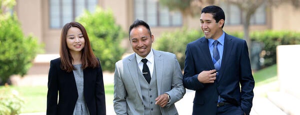 3 AGSM students walking around Anderson Hall