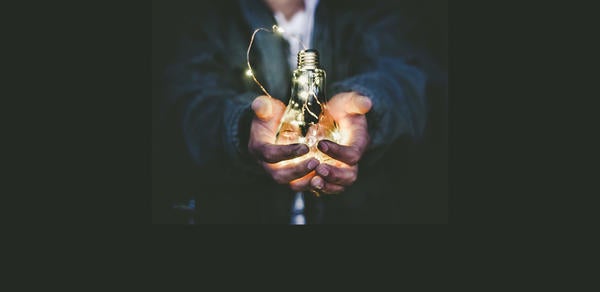 hands holding a glowing lightbulb (c) Riccardo Annandale unsplash