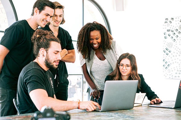 group of students looking at a laptop