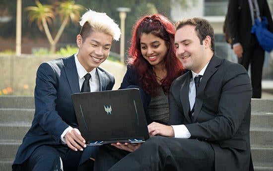 Three UCR Students looking at a computer