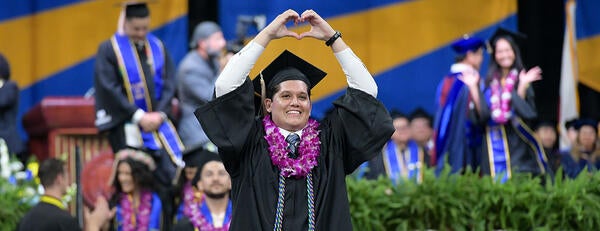 UCR Business student walking at the 2024 Commencement Ceremony