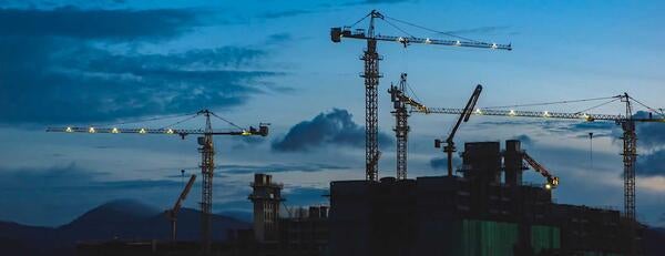 Construction site with cranes after dark in California