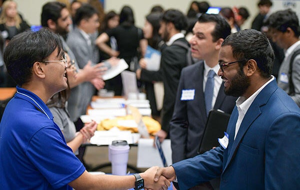 Two folks shaking hands at a CDC Career Fair