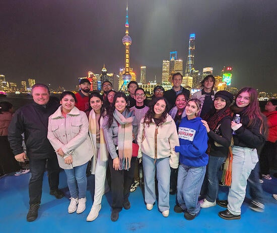 UCR School of Business students standing in front of the Huangpu river, with the city of Shanghai behind them.